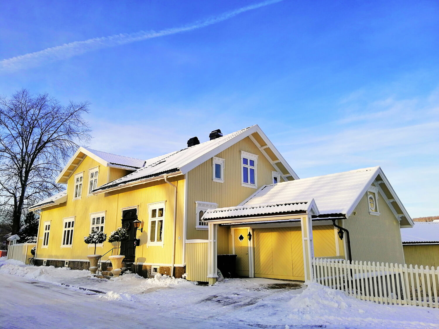 Mission Gutter Services – Installation, Repair & Cleaning Yellow house with snow-covered roof and gutters