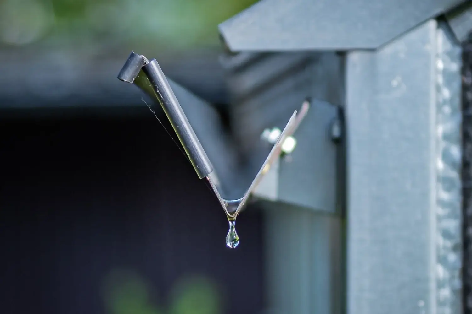 Close-up of a water droplet on a metal roof, symbolizing gutter durability and weather resistance